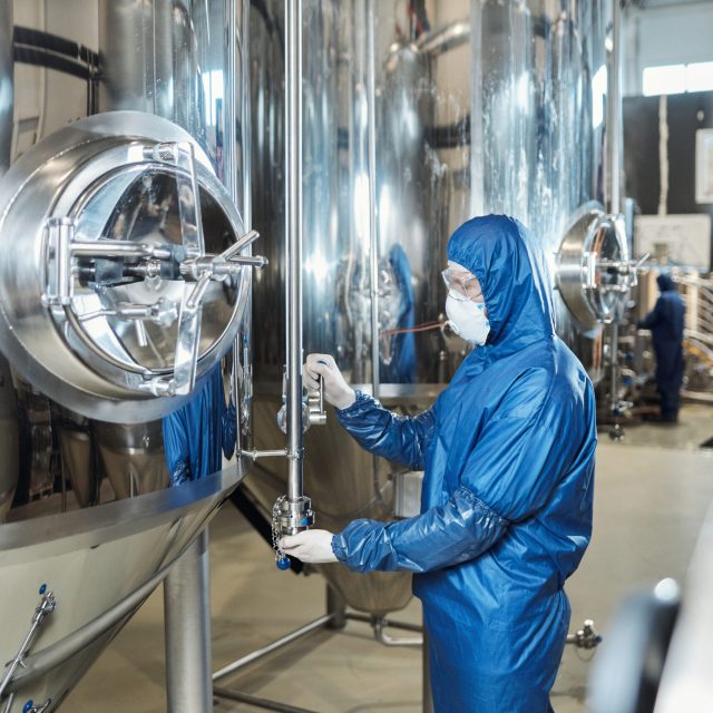 Side view of worker wearing protective gear at chemical plant